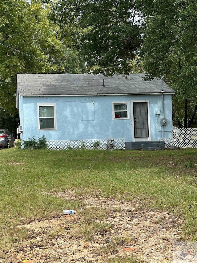 back of house with a lawn