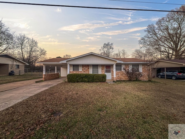 ranch-style home featuring a yard and a carport