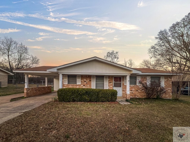 ranch-style home with a lawn and a carport