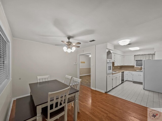 dining area with sink, light hardwood / wood-style flooring, and ceiling fan