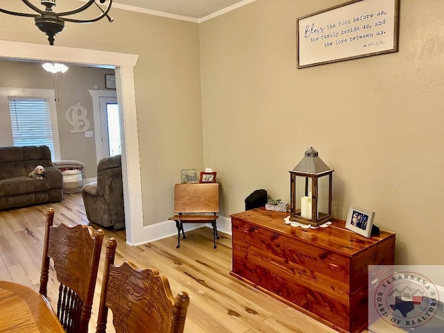 living area with ornamental molding, wood finished floors, and baseboards