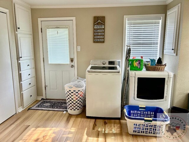 laundry room with laundry area, crown molding, light wood-style floors, and washing machine and clothes dryer