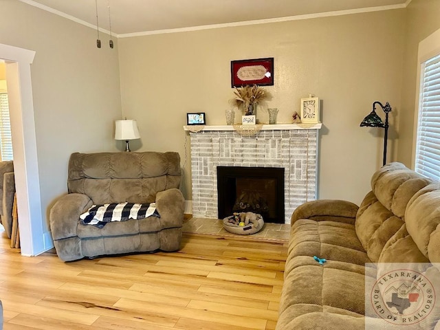 living area featuring a brick fireplace, wood finished floors, and crown molding