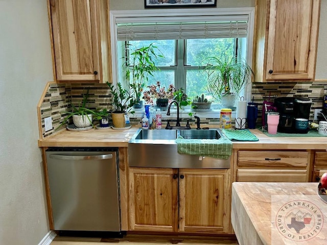 kitchen featuring light brown cabinets, a sink, wooden counters, stainless steel dishwasher, and backsplash