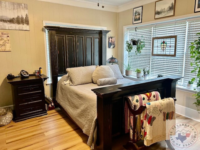 bedroom with ornamental molding and wood finished floors