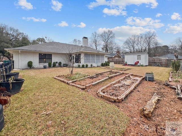 back of house with a yard and a storage unit