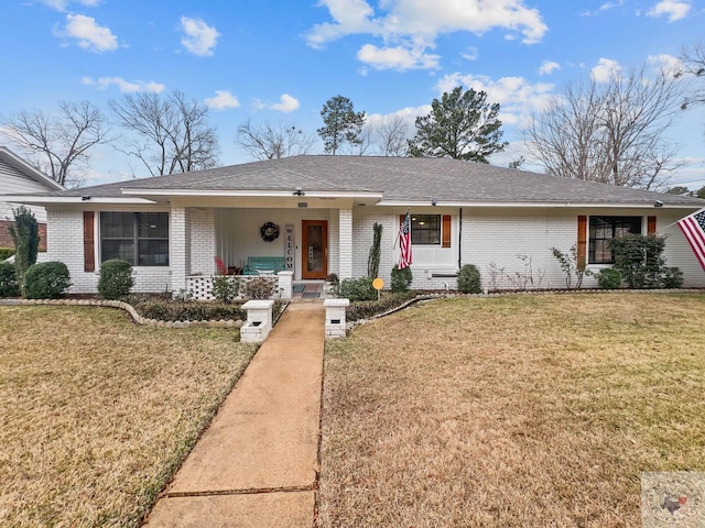 ranch-style house featuring covered porch and a front lawn