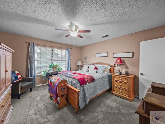 carpeted bedroom with ceiling fan and a textured ceiling