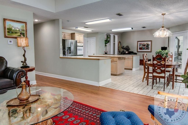 living room featuring a textured ceiling and light wood-type flooring