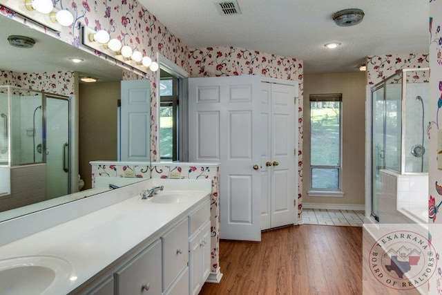 bathroom featuring toilet, hardwood / wood-style floors, a textured ceiling, walk in shower, and vanity