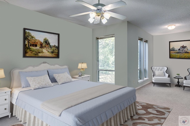 bedroom featuring ceiling fan, a textured ceiling, and light carpet