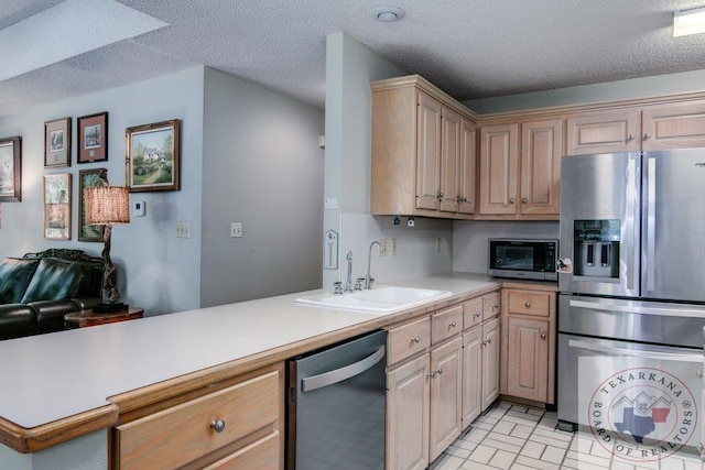 kitchen with appliances with stainless steel finishes, a textured ceiling, sink, kitchen peninsula, and light brown cabinets