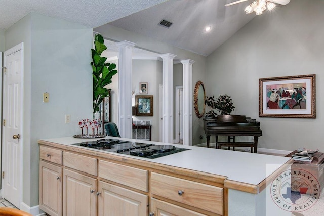 kitchen featuring light brown cabinets, ornate columns, black gas cooktop, kitchen peninsula, and vaulted ceiling