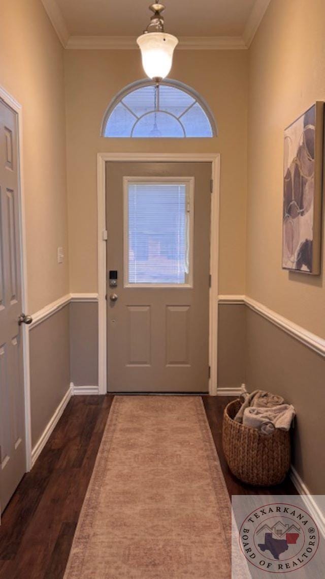 entryway with dark wood-type flooring and crown molding