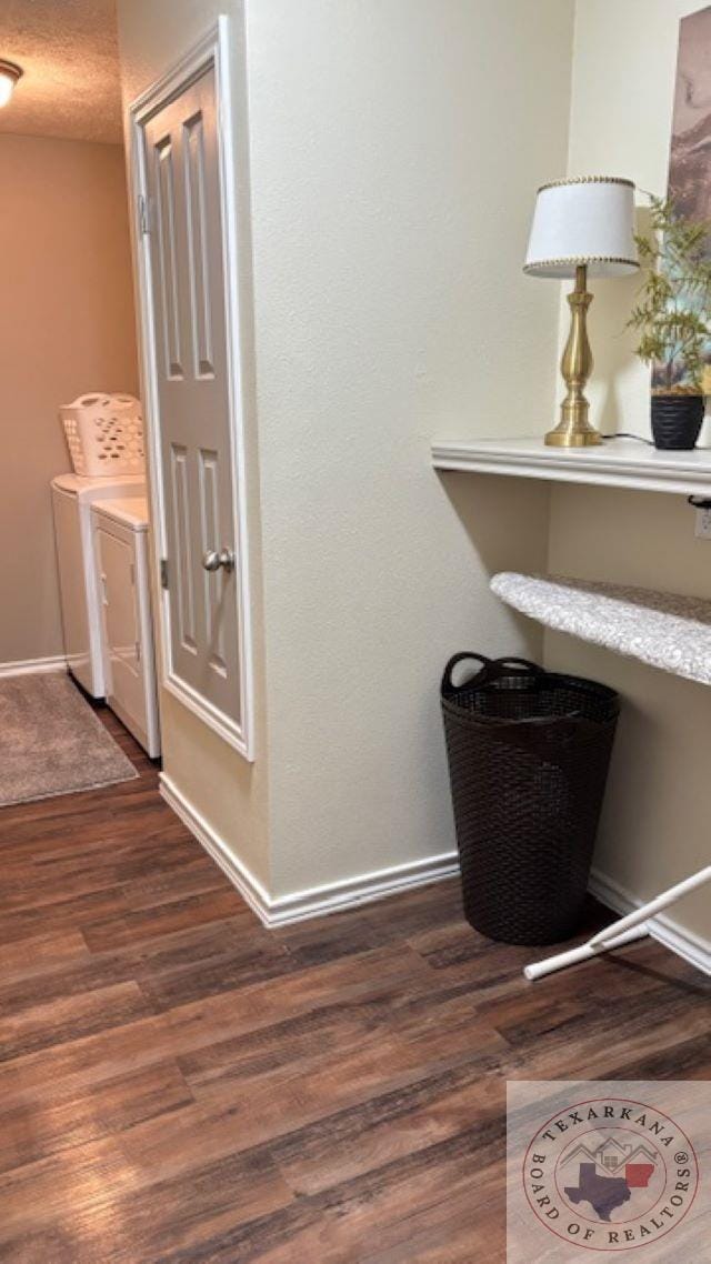 hall with independent washer and dryer, a textured ceiling, and dark hardwood / wood-style floors