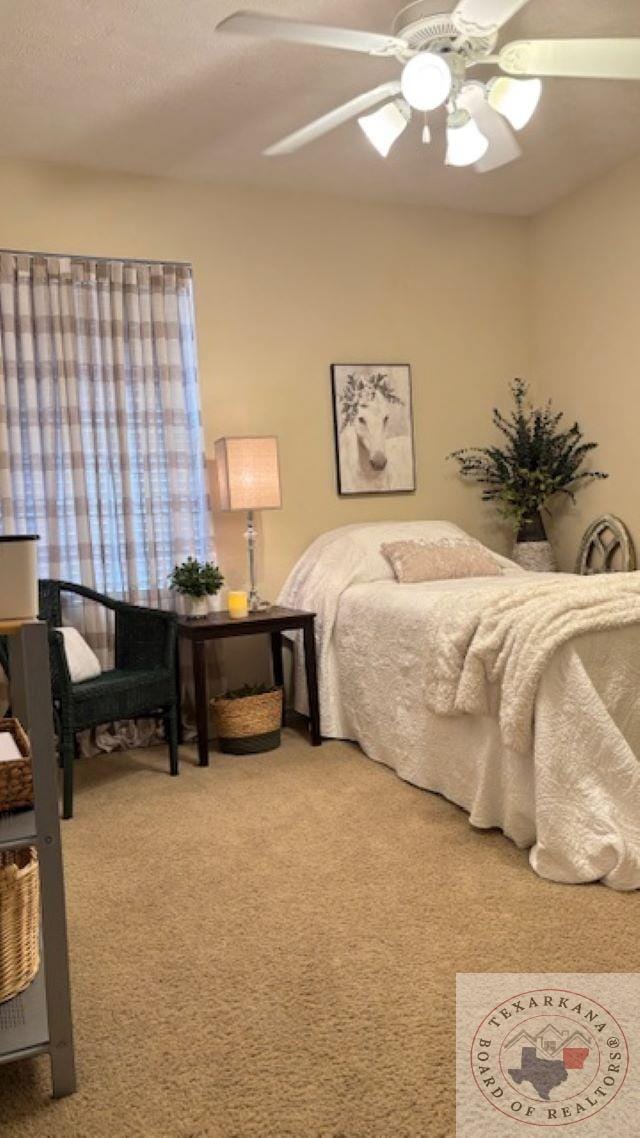 bedroom featuring ceiling fan and carpet