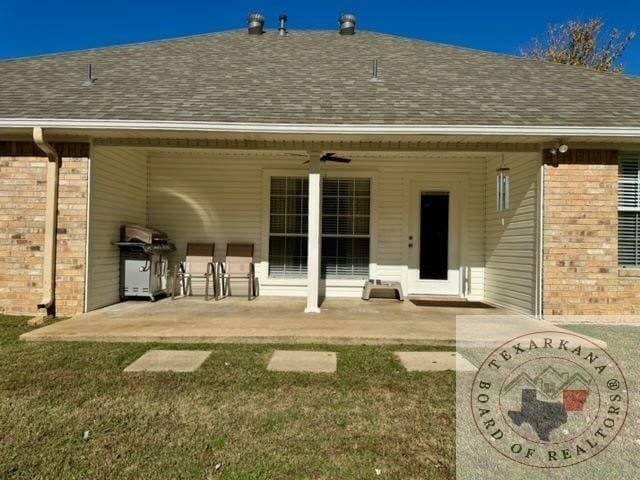 rear view of house with ceiling fan, a patio, and a yard