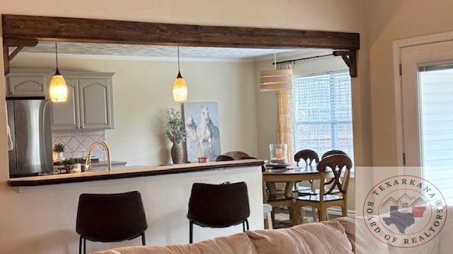 kitchen featuring decorative light fixtures, tasteful backsplash, sink, stainless steel fridge, and gray cabinets