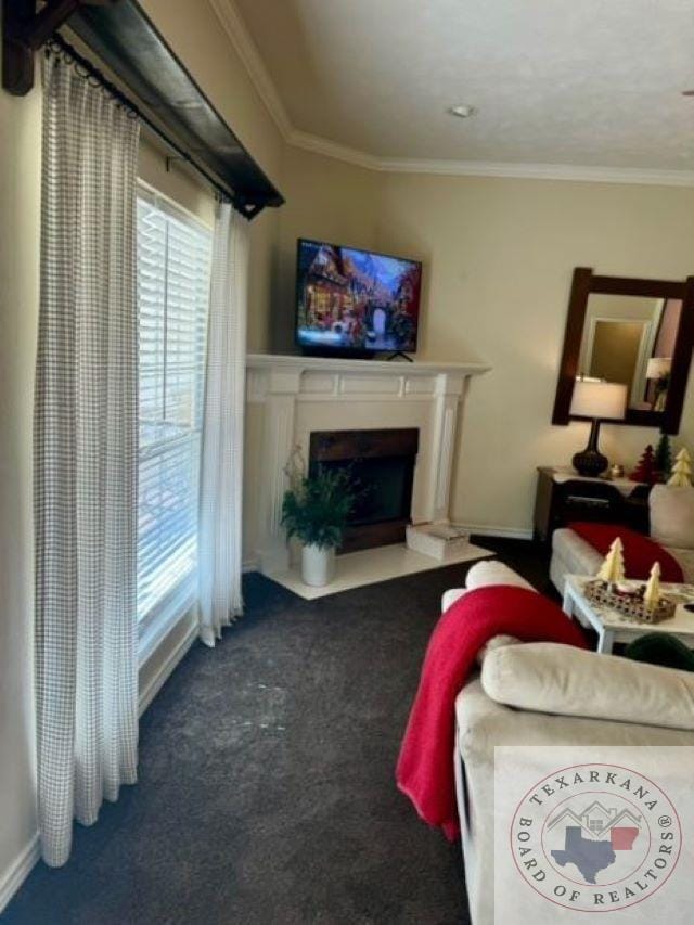 living room featuring dark colored carpet and ornamental molding