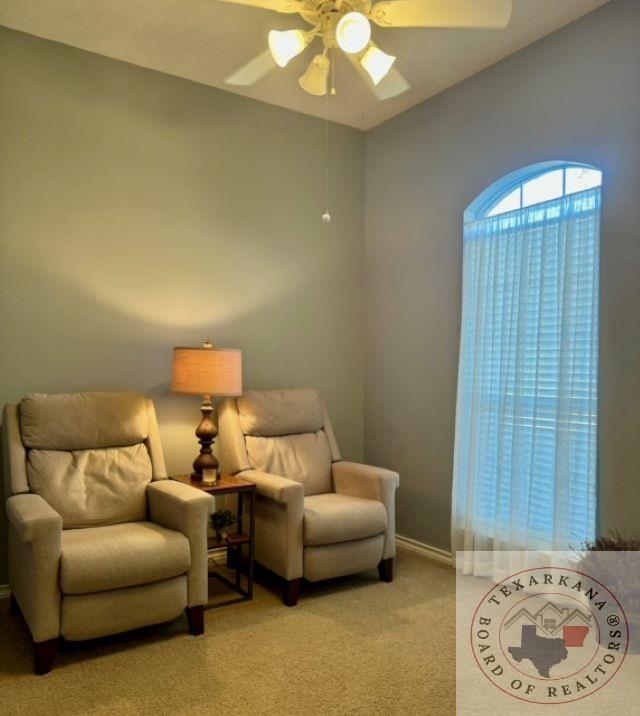 living area featuring ceiling fan and light carpet