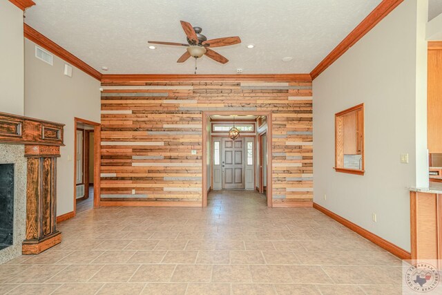 676 Akin Rd, Texarkana, TX 75503 - unfurnished living room featuring a textured ceiling, a fireplace, wooden walls, ceiling fan, and crown molding