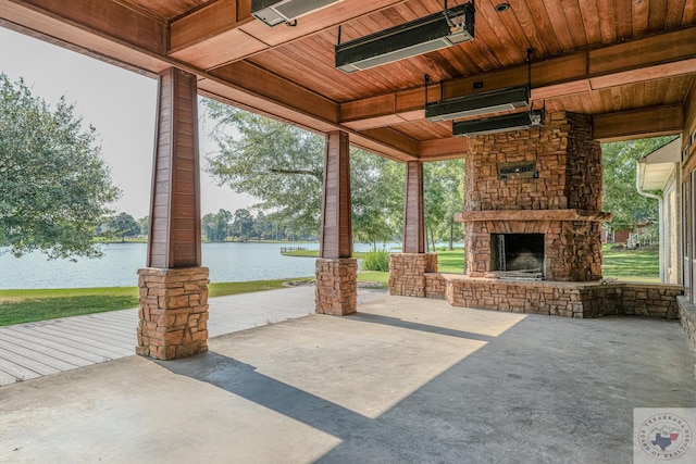 view of patio featuring an outdoor stone fireplace and a water view