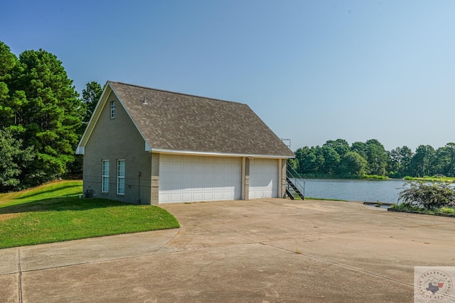 garage with a lawn and a water view