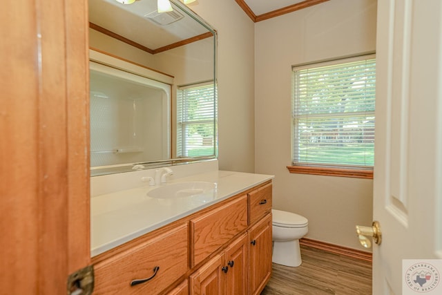 bathroom featuring wood-type flooring, toilet, vanity, and ornamental molding