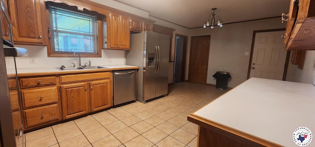 3507 Belmont Ave, Texarkana, AR 71854 - kitchen featuring appliances with stainless steel finishes, light tile patterned floors, light countertops, brown cabinets, and a chandelier