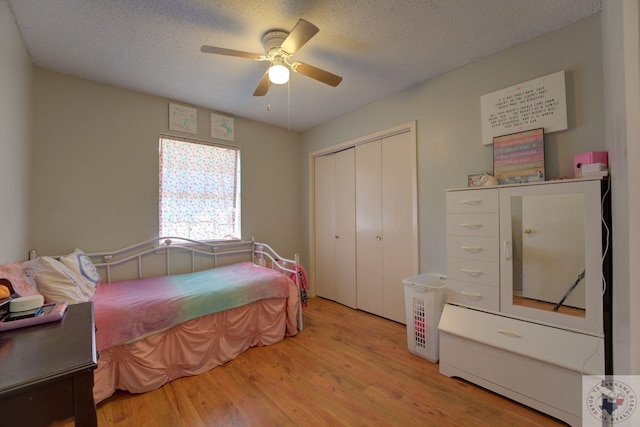 bedroom featuring ceiling fan, a textured ceiling, a closet, and light wood-type flooring