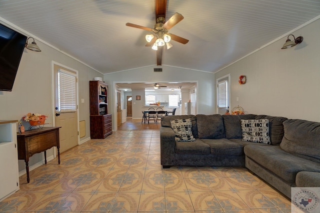 living room featuring ceiling fan, light tile patterned floors, ornamental molding, and lofted ceiling