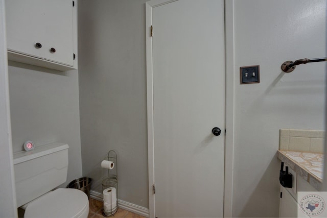 bathroom featuring toilet and tile patterned flooring