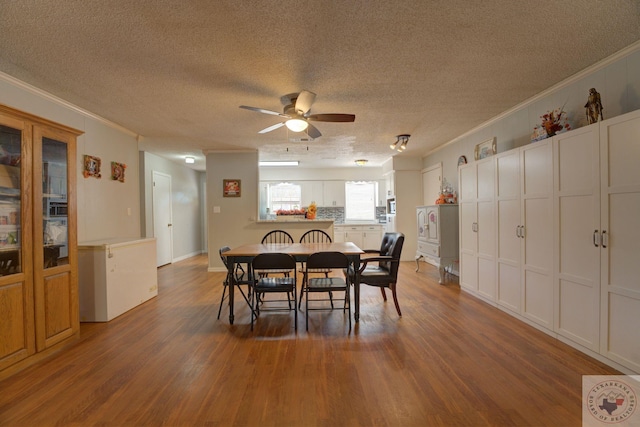 dining area featuring hardwood / wood-style flooring, ceiling fan, ornamental molding, and a textured ceiling