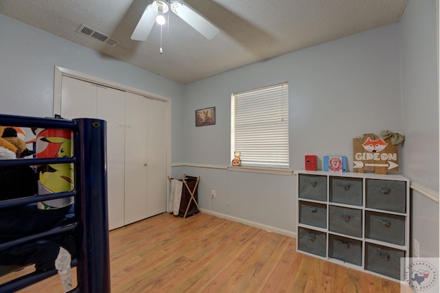 interior space with a closet, ceiling fan, light hardwood / wood-style flooring, and a textured ceiling