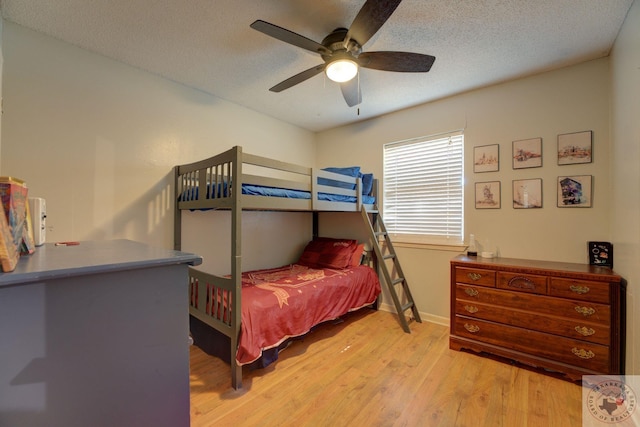 bedroom featuring ceiling fan, light hardwood / wood-style floors, and a textured ceiling