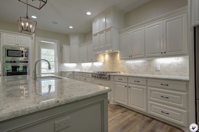 8907 River Ridge Drive, Texarkana, TX 75503 - kitchen featuring stainless steel appliances, a sink, white cabinetry, light stone countertops, and recessed lighting