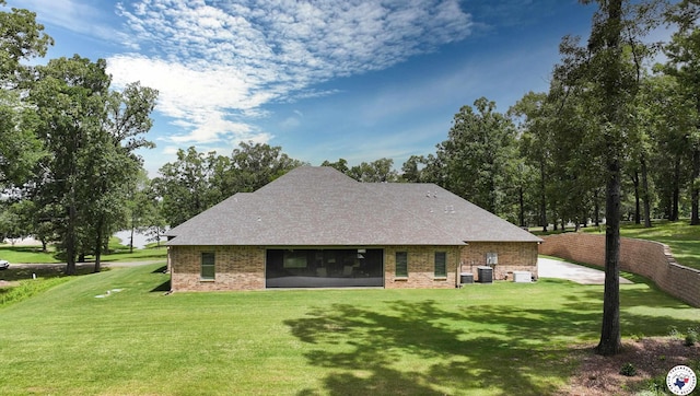 8907 River Ridge Drive, Texarkana, TX 75503 - back of house featuring a yard, central air condition unit, roof with shingles, and brick siding