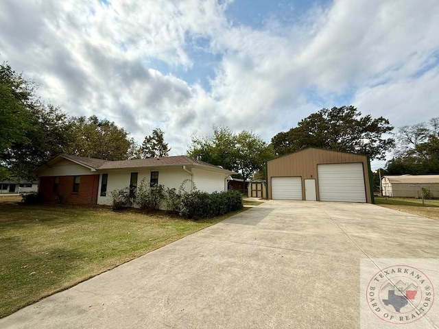 ranch-style home with a front yard, an outdoor structure, and a garage