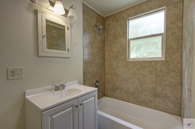 bathroom featuring tiled shower / bath combo and vanity