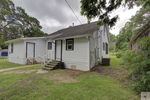 view of front of house featuring cooling unit and a front lawn