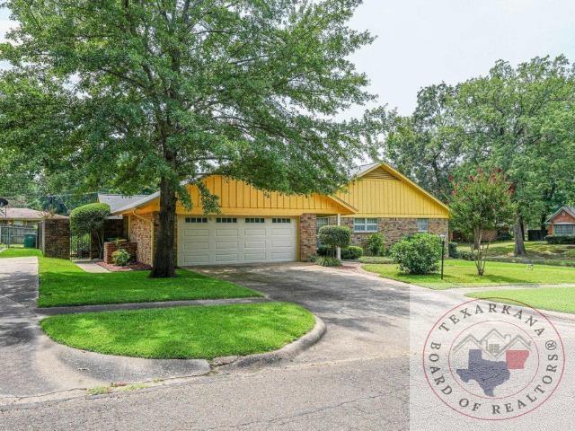 ranch-style house with a garage, driveway, and a front lawn