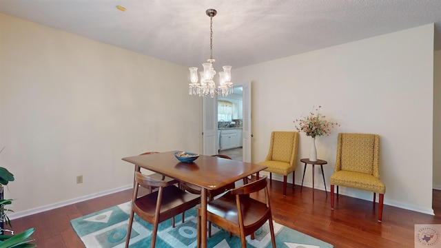 dining space featuring a chandelier, baseboards, and hardwood / wood-style floors