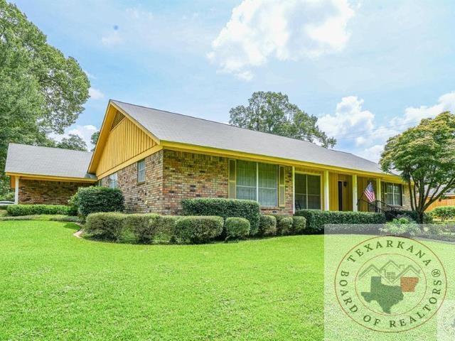 ranch-style home featuring brick siding and a front yard