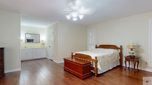 bedroom featuring baseboards, dark wood-type flooring, and a textured ceiling