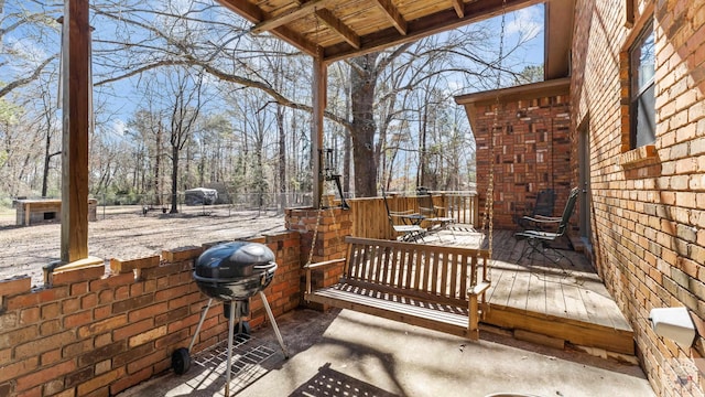 view of patio with area for grilling and a wooden deck