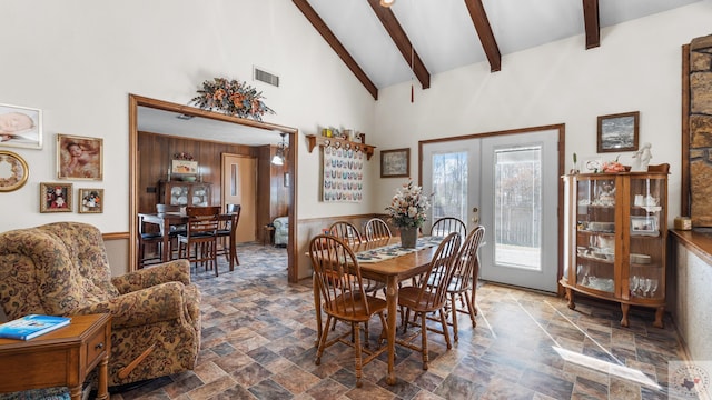 dining room featuring high vaulted ceiling, french doors, stone finish floor, and visible vents