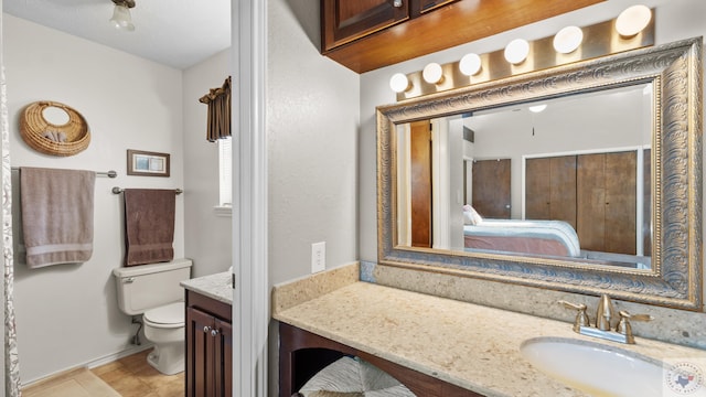 bathroom with vanity, toilet, and ensuite bathroom