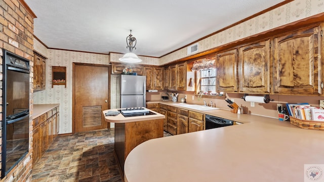 kitchen with a sink, ornamental molding, black appliances, stone finish floor, and wallpapered walls