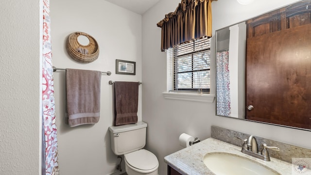 bathroom featuring toilet and vanity