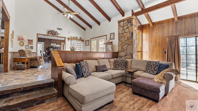 living room featuring high vaulted ceiling, wood finished floors, visible vents, a ceiling fan, and beam ceiling